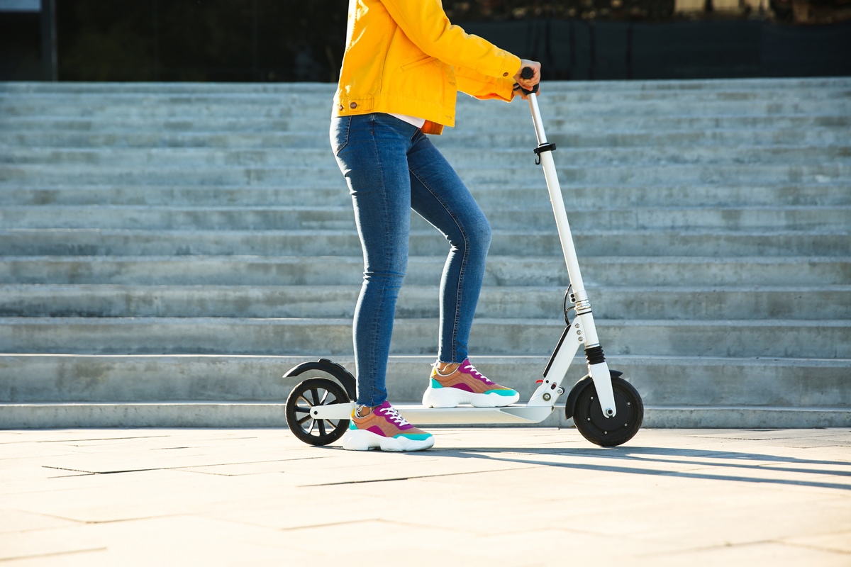 Person standing with an escooter.